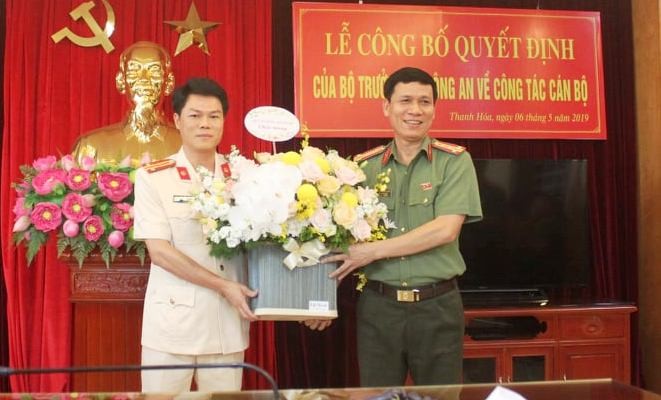 Đại tá Dương Văn Tiến - Phó Giám đốc Công an tỉnh Thanh Hóa tặng hoa cho Trung tá Nguyễn Hữu Mạnh (ảnh trái). Ảnh: Công an Thanh Hóa cung cấp.