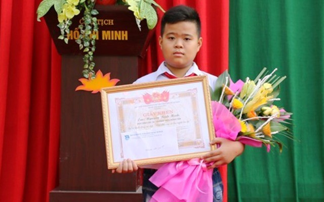 Em Nguyễn Bình Minh, học sinh lớp 7A, Trường THCS Đông Tân, TP.Thanh Hóa đón nhận giấy khen của Chủ tịch UBND TP.Thanh Hóa.