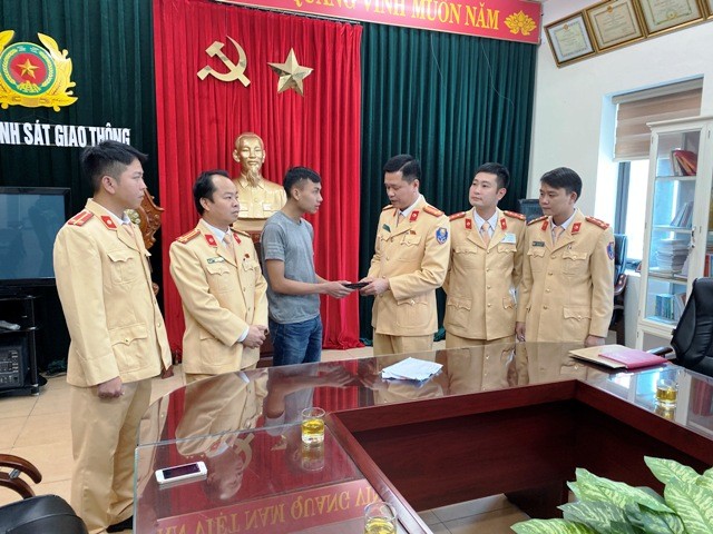 Phòng CSGT Công an Thanh Hóa trao lại chiếc ví tiền cho anh Hoàng Văn Nam.