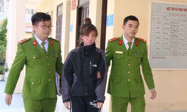 Lực lượng công an dẫn giải Nguyễn Thị Thu Thương về nơi tạm giữ hình sự. Ảnh: Công an Thanh Hóa cung cấp.