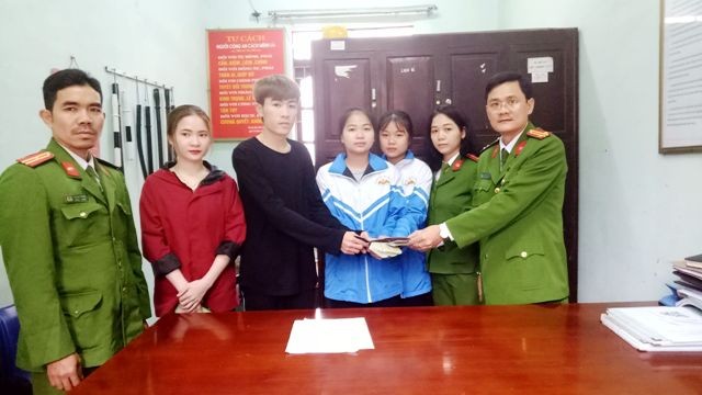 Trung tá Trịnh Tứ Dũng – Phó trưởng Công an phường Đông Sơn (ngoài cùng bên phải) trao lại số tiền do hai nữ sinh nhặt được cho người làm rơi.