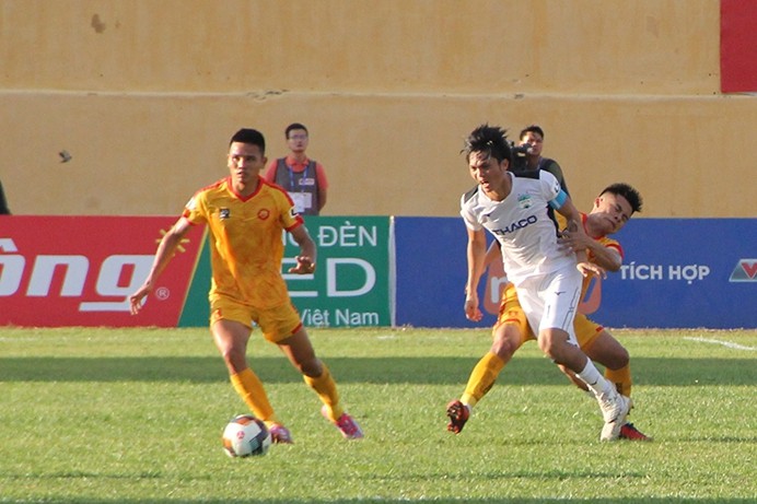 Cầu đội bóng Đông Á Thanh Hóa (áo vàng) trong một pha tranh bóng. Ảnh: Mạnh Cường