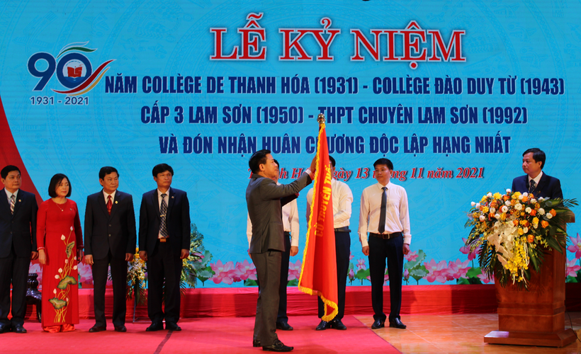 Thừa quỷ quyền Chủ tịch nước, ông Đỗ Trọng Hưng - Bí thư Tỉnh ủy Thanh Hóa gắn Huân chương Độc lập hạng Nhất lên lá cờ truyền thống của nhà trường.