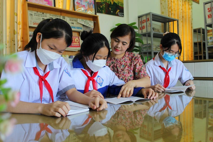 Cô Nguyễn Thị Thu Hà cùng học sinh tại thư viện của nhà trường. Hiện nay, ngoài sách giáo khoa, nhà trường còn bổ sung nhiều đầu sách pháp luật.