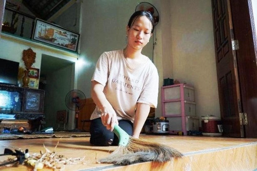Nữ sinh Nguyễn Thị Thùy giúp mẹ quét nhà.