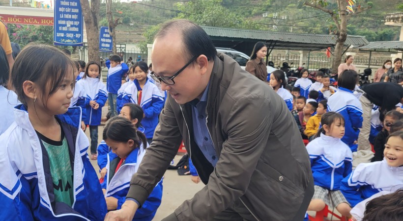Nhà báo Hà Đồng - PV thường trú, Báo Tuổi trẻ tại Thanh Hóa trao áo cho học sinh. Ảnh: TL