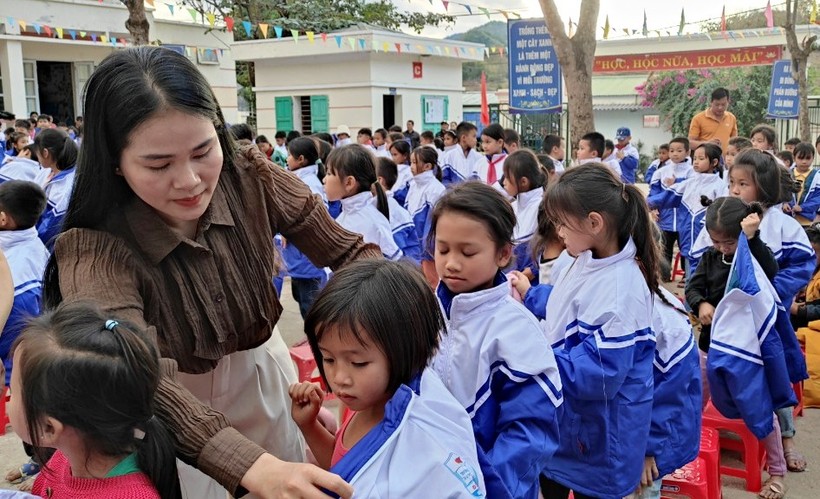 Cô giáo Trường Tiểu học Quang Chiểu 2 mặc áo cho học trò của mình. Ảnh: TL