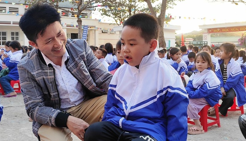 Thầy Bùi Xuân Thảo - Phó Hiệu trưởng nhà trường mặc áo cho học sinh. Ảnh: TL