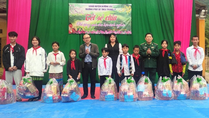Nhà báo Hà Đồng - Phóng viên thường trú Báo Tuổi trẻ TP Hồ Chí Minh tại Thanh Hóa (người đeo kính) tặng quà học sinh nghèo tại Trường PTDTBT-THCS Trung Lý. Ảnh: TL