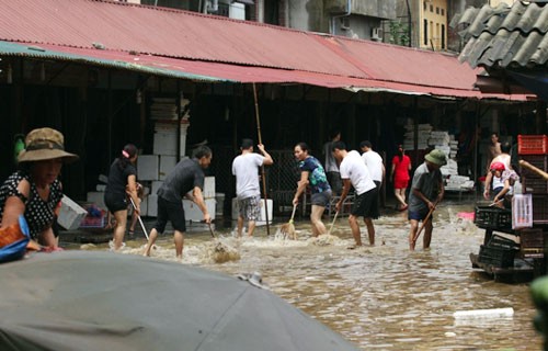 Tiểu thương chợ Giếng Vuông (Lạng Sơn) dọn dẹp sau khi nước rút. Ảnh: Ngọc Thành
