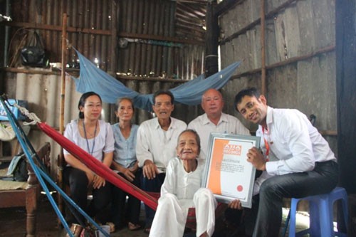 Tổng Giám đốc Tổ chức Kỷ lục châu Á Biswaroop Roy Chowhury trao bằng xác lập kỷ lục Cụ bà cao tuổi nhất châu Á cho cụ Nguyễn Thị Trù Ảnh: VietKings cung cấp