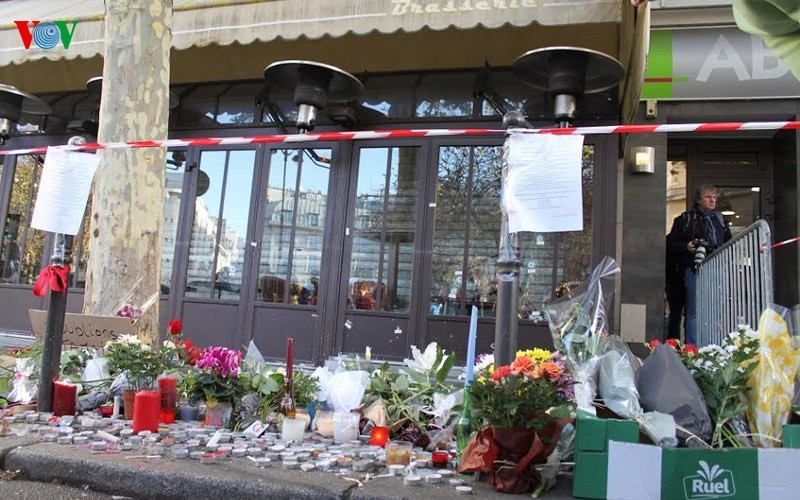 Người dân đặt hoa tưởng niệm các nạn nhân trước quán cà phê Bonne Biere tại quận 10 (Paris).