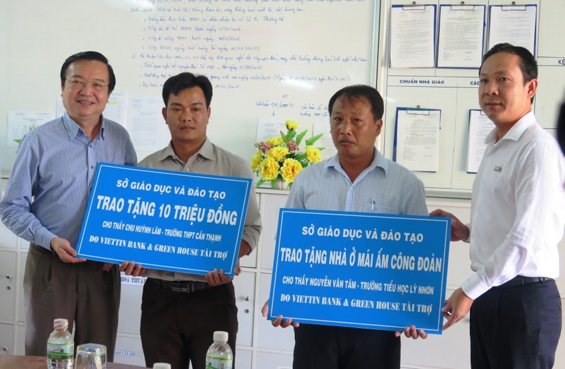 Ông Lê Hồng Sơn - Giám đốc Sở GD&ĐT TP HCM (bên trái) cùng nhà tài trợ Vietinbank trao quà, hỗ trợ cho các giáo viên 