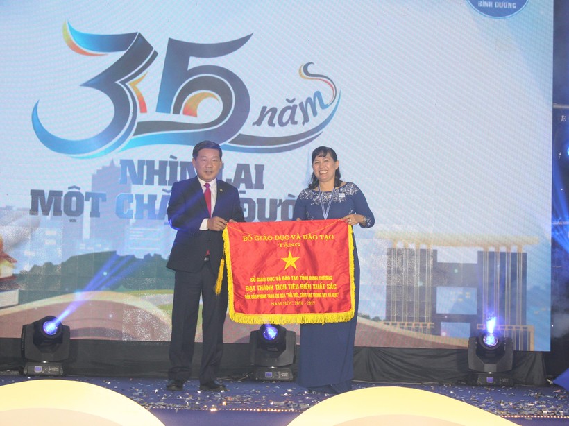 Ông Trần Thanh Liêm- Chủ tịch UBND tỉnh Bình Dương trao cờ thi đua của Bộ GD&ĐT cho đại diện lãnh đạo Sở GD&ĐT