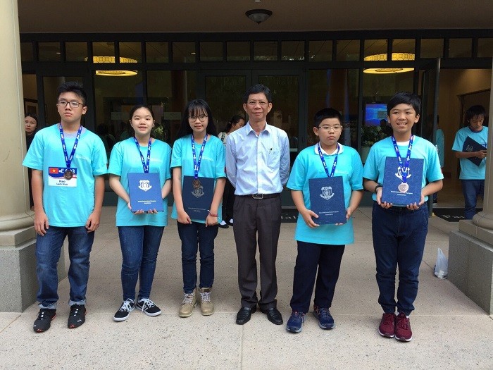 Thầy Lâm Triều Nghi, Hiệu trưởng Trường THPT chuyên Trần Đại Nghĩa chụp ảnh chung với các học sinh đạt giải tại cuộc thi Toán học thế giới 2018