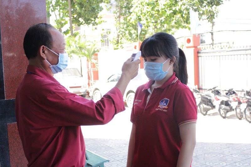 Học sinh Trường THCS-THPT Đào Duy Anh, TP.HCM kiểm tra thân nhiệt trước khi vào trường. Ảnh minh hoạ