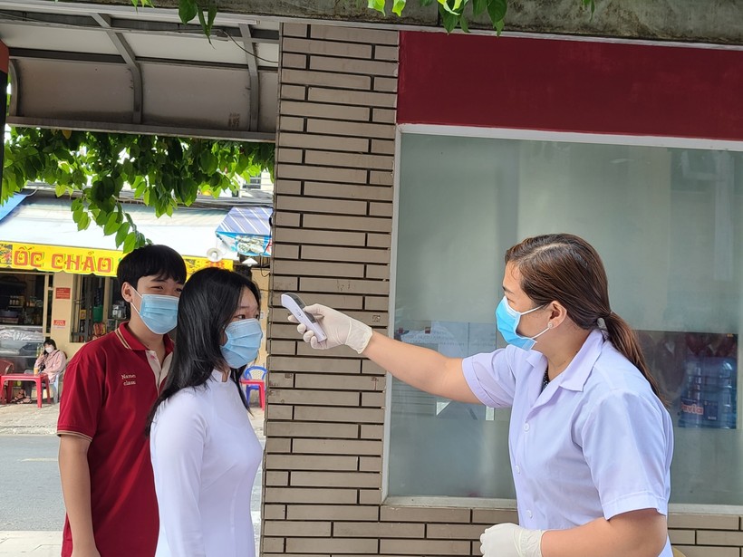 Học sinh Trường THCS-THPT Đào Duy Anh, TP.HCM kiểm tra thân nhiệt trước khi vào trường. Ảnh minh hoạ T.Minh