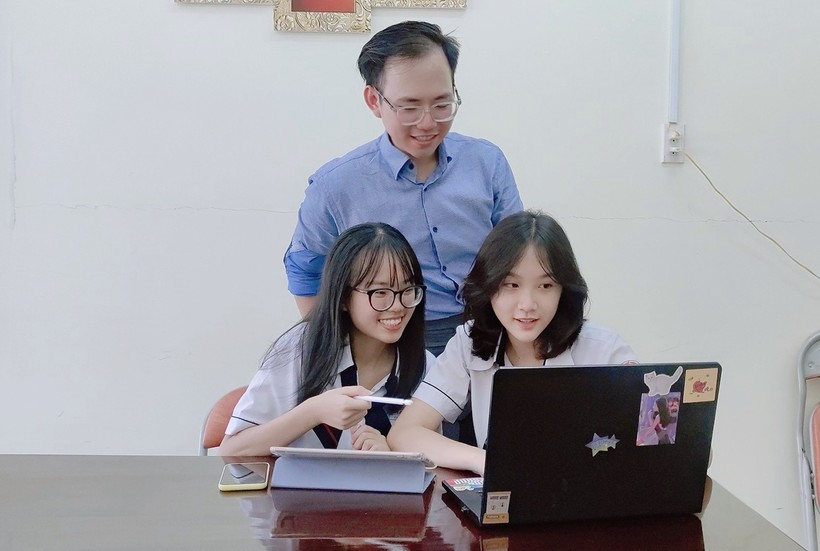Em Trần Xuân Anh Khuê và Ngô Gia Nghi cùng thầy giáo Nguyễn Minh Trung (Trường THPT Gia Định, TP.HCM) xem lại sản phẩm tham gia cuộc thi. Ảnh NVCC