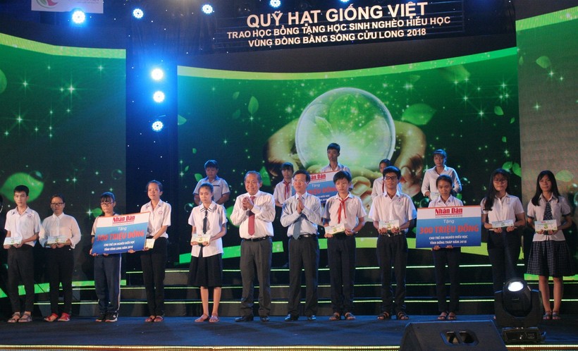 Đồng chí Trương Hoà Bình - Phó Thủ tướng Thường trực Chính phủ và đồng chí Võ Văn Thưởng - Trưởng Ban Tuyên giáo Trung ương trao học bổng cho các em HS