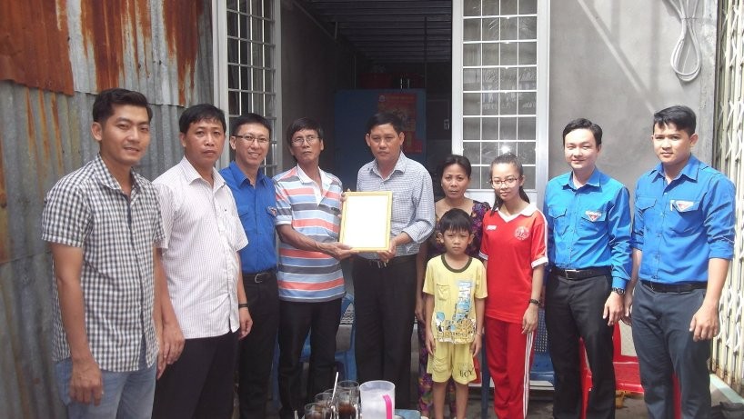 Buổi trao nhà Nhân ái cho gia đình em Huỳnh Thị Diễm (áo đỏ) với sự có mặt của chính quyền địa phương và Trường Trường THPT Hồ Thị Kỷ