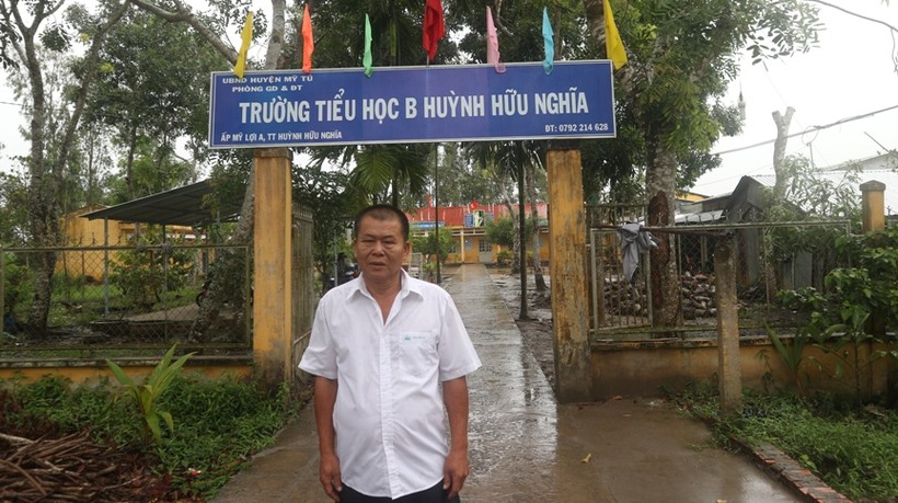 Ông Trần Văn Đôi bên Trường Tiểu học B Huỳnh Hữu Nghĩa -  nơi ông hiến đất xây dựng