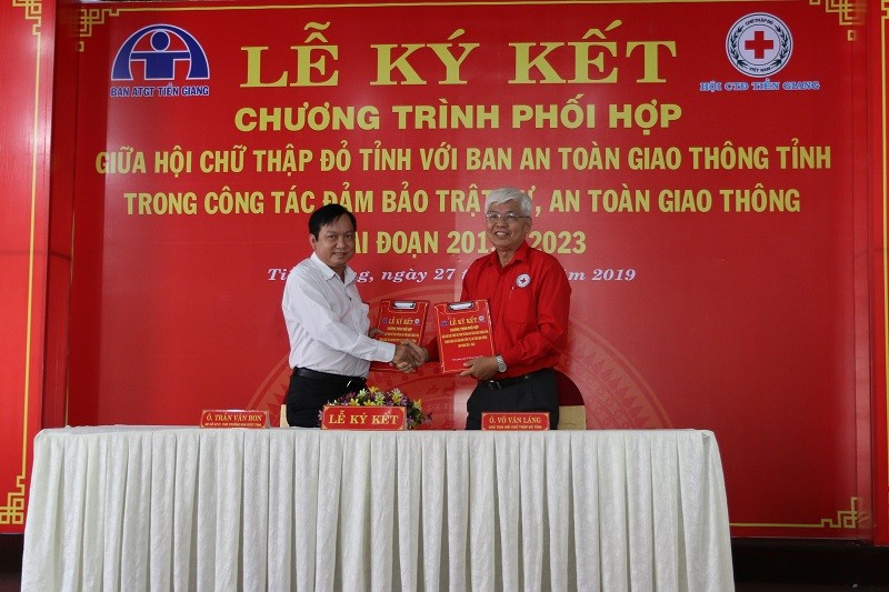 Giám đốc Sở GTVT, Phó Trưởng ban thường trực ATGT tỉnh Tiền Giang Trần Văn Bon (trái) và Chủ tịch Hội Chữ thập đỏ tỉnh Võ Văn Láng ký kết thỏa thuận. Ảnh: X. Uyên