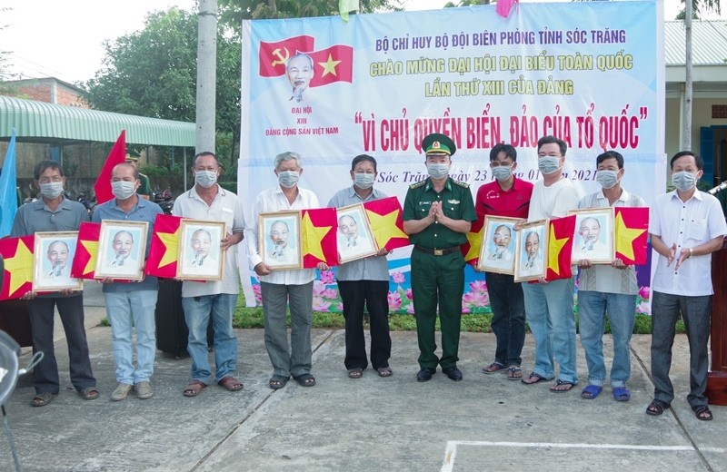 Đại tá Lê Văn Anh, Phó Chính uỷ, BĐBP tỉnh trao cờ Tổ quốc và ảnh Bác Hồ cho ngư dân.