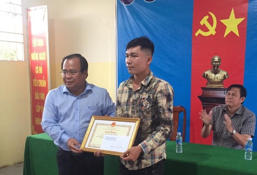 Phó Chủ tịch UBND tỉnh Cà Mau Nguyễn Minh Luân trao bằng khen cho anh Nguyễn Hiền Phong.