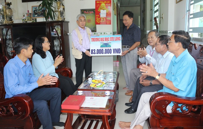 PGS.TS Lương Minh Cừ, Bí thư Đảng ủy, Hiệu trưởng Trường ĐH Cửu Long (bên trái) trao số tiền hỗ trợ gia đình anh Nguyễn Minh Trường.