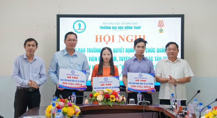 TS Trương Tấn Đạt, Chủ tịch Hội đồng trường (trái) và TS Hồ Văn Thống, Hiệu trưởng trao gói hỗ trợ viên chức tuyển dụng mới có học vị tiến sĩ.
