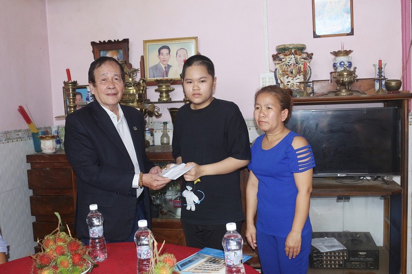Thạc sĩ Nguyễn Cao Đạt - Chủ tịch Hội Khuyến học Trường ĐH Cửu Long trao tiền hỗ trợ cho em Trúc Đào.