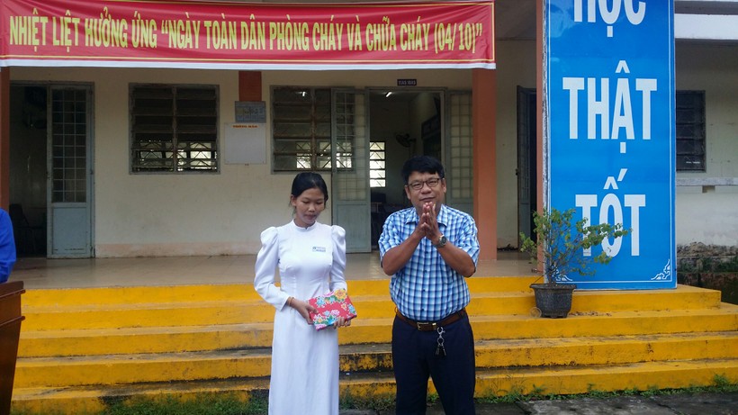 BGH Trường THPT Vĩnh Hải tuyên dương em Kim Thoa trong tiết sinh hoạt dưới cờ.