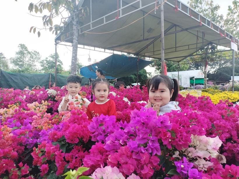 Các em nhỏ chụp hình “check-in” tại khu vực chợ hoa kiểng TP Cà Mau.