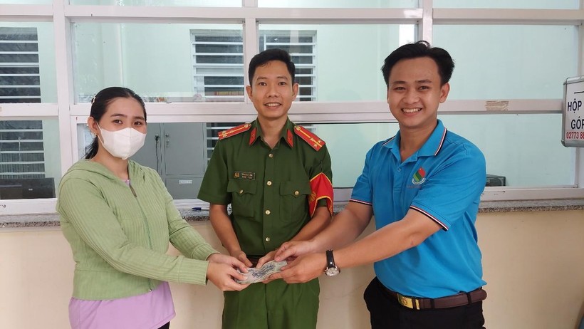 Công an phường 6 và em Nguyễn Minh Toàn bàn giao lại chiếc ví cho chị Lê Thị Huỳnh Oanh. Ảnh: NVCC.