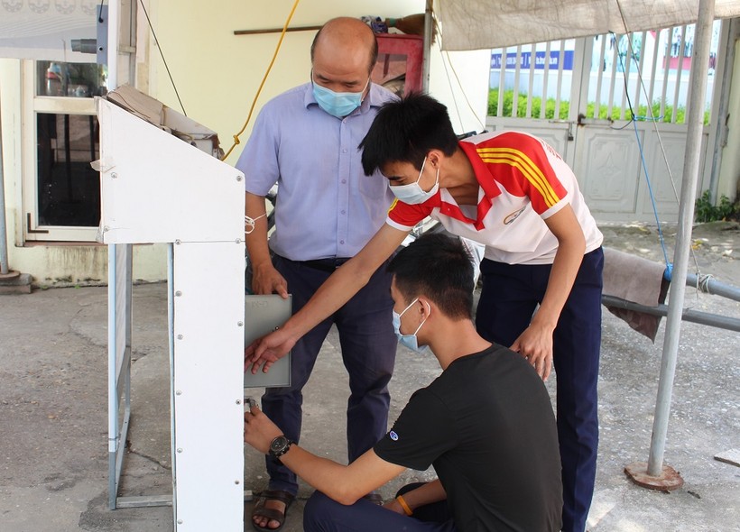PGS.TS Phạm Thành Long cùng nhóm sinh viên Trường Đại học Kỹ thuật Công nghiệp bên máy đo thân nhiệt và rửa tay tự động phòng dịch Covid-19.