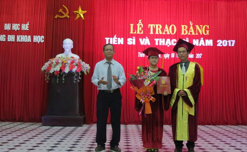 PGS.TS.Hoàng Văn Hiển, Hiệu trưởng Trường ĐHKH Huế trao bằng và hoa cho tân tiến sĩ
 