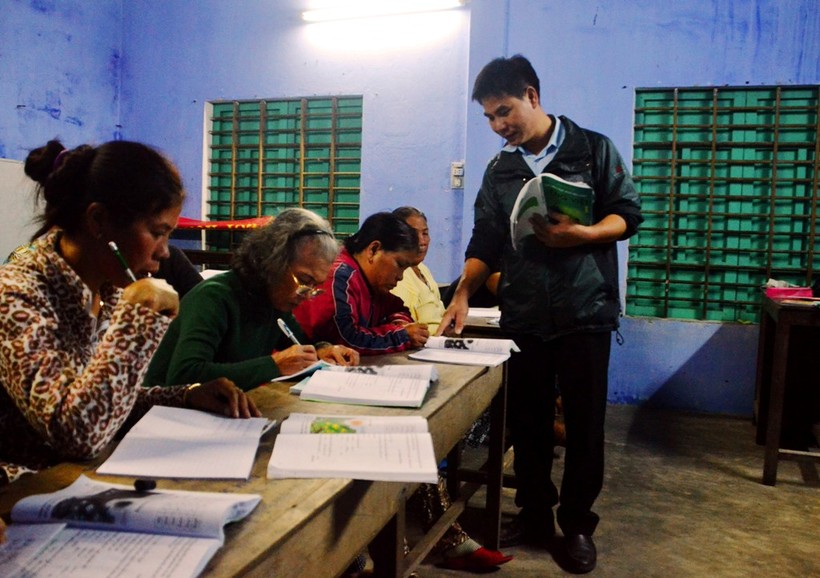 Thầy giáo Huỳnh Văn Hưng tận tình hướng dẫn mặt chữ cho những học viên trong lớp