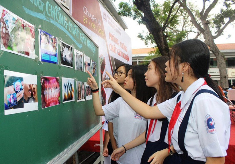 Học sinh Trường THCS Lê Quý Đôn, quận 3 tìm hiểu thông tin về tác hại của các chất gây nghiện tại bảng tin nhà trường.	Ảnh: Hoàng Lan