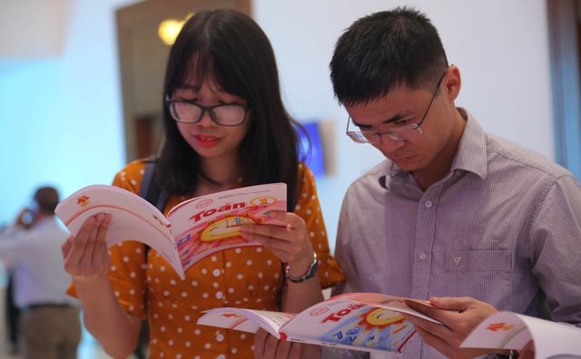 Các giáo viên tham khảo các bộ sách mẫu tại một hội thảo giới thiệu SGK của Nhà xuất bản Giáo dục Việt Nam.  	Ảnh: Việt Hà