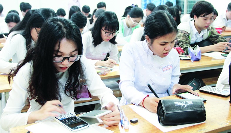 HS Trường THPT Trần Hữu Trang kiểm tra trực tuyến giữa kỳ I bằng smartphone.  Ảnh: P. Nga             
