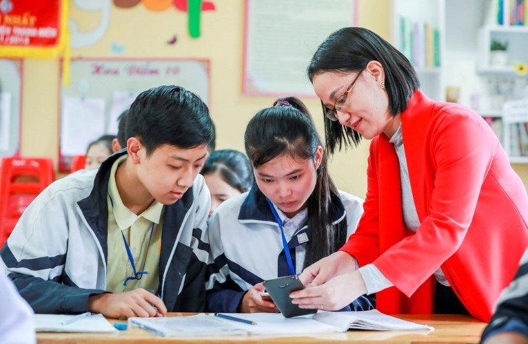 Giáo viên Trường THPT số 2 Bảo Thắng (Lào Cai) hướng dẫn học sinh tìm tài nguyên học tập trên smartphone. Ảnh: IT 