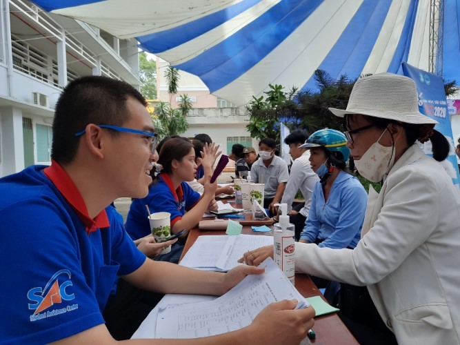 Các tình nguyện viên tư vấn cho phụ huynh về nhà trọ tại Trường ĐH Sài Gòn. Ảnh: TG