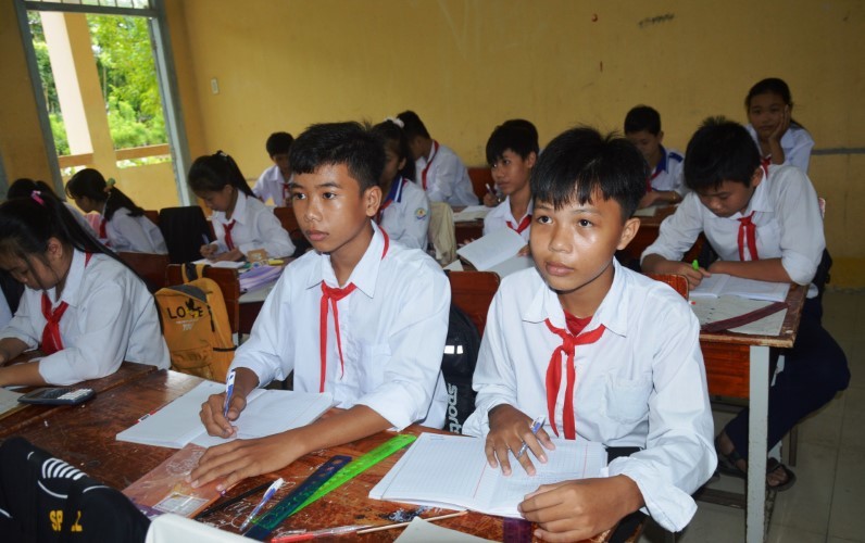 Em Thái Trọng Nhân (ngồi giữa, hàng đầu) trở về từ Campuchia đã hoàn thành cách ly và đi học cùng các bạn.