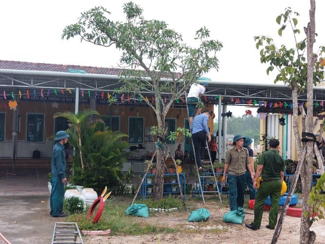 Lực lượng chức năng hỗ trợ thực hiện công tác phòng chống bão tại các cơ sở giáo dục ở Thừa Thiên Huế . Ảnh do địa phương cung cấp.