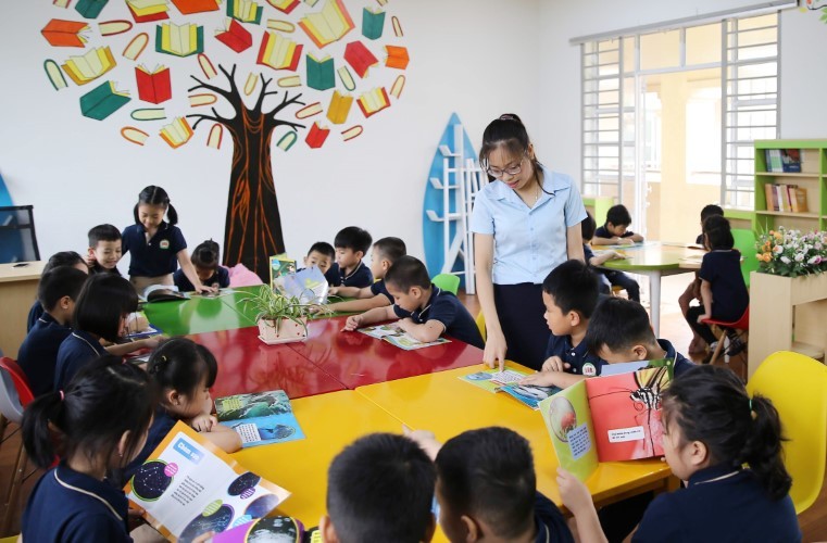 Giáo viên hướng dẫn học sinh đọc sách tại Trường Tiểu học Gia Sàng (TP Thái Nguyên). Ảnh: Thế Đại