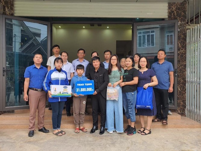 Thầy Đào Chí Mạnh ( thứ tư từ trái sang) trao hơn 30 triệu đồng và quà cho 2 chị em Trần Khánh An. Ảnh: NVCC
