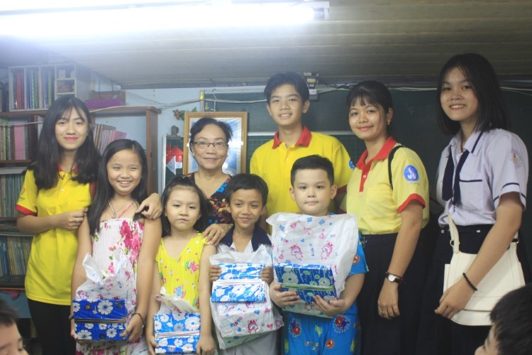 Học sinh Trường THCS - THPT Đào Duy Anh (TPHCM) tặng quà cho các em nhỏ ở lớp học tình thương. Ảnh: P.Nga