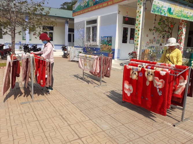Giáo viên Trường Mầm non Mường Đun tranh thủ nắng mới giặt chăn, màn cho học sinh.