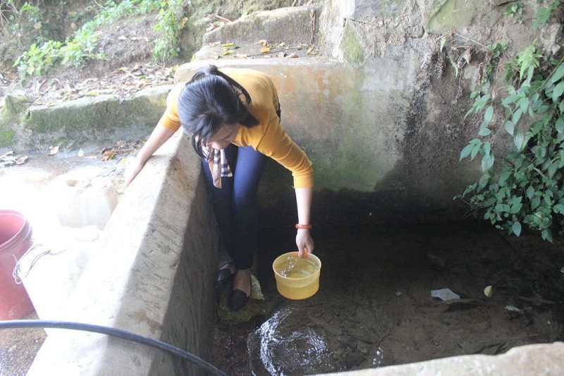 Cô giáo Nguyễn Thị Thương, giáo viên Trường Mầm non Sính Phình (xã Sính Phình, huyện Tủa Chùa) gạn từng gáo nước dưới đáy mó cạn kiệt cách xa trường hơn 1km.