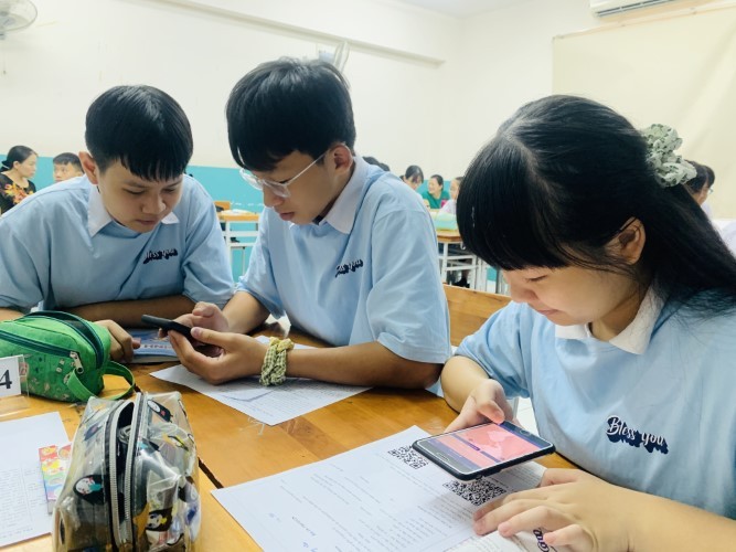 Học sinh Trường THCS Nguyễn Du, Quận 1 tham gia tiết học được phép sử dụng điện thoại. Các em quét mã QR Code được giáo viên mã hóa để vào bài học. Ảnh: P.Nga 
